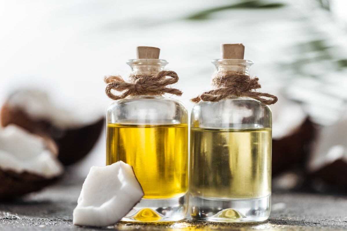 selective focus of bottles with coconut oil near coconut piece