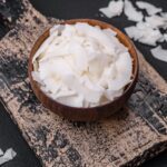 White dry coconut flakes in a wooden bowl prepared for making desserts
